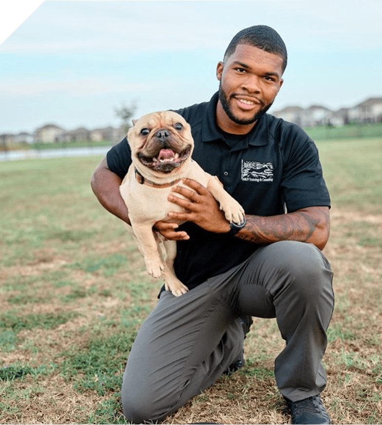 Man happily holding a bulldog puppy outdoors.