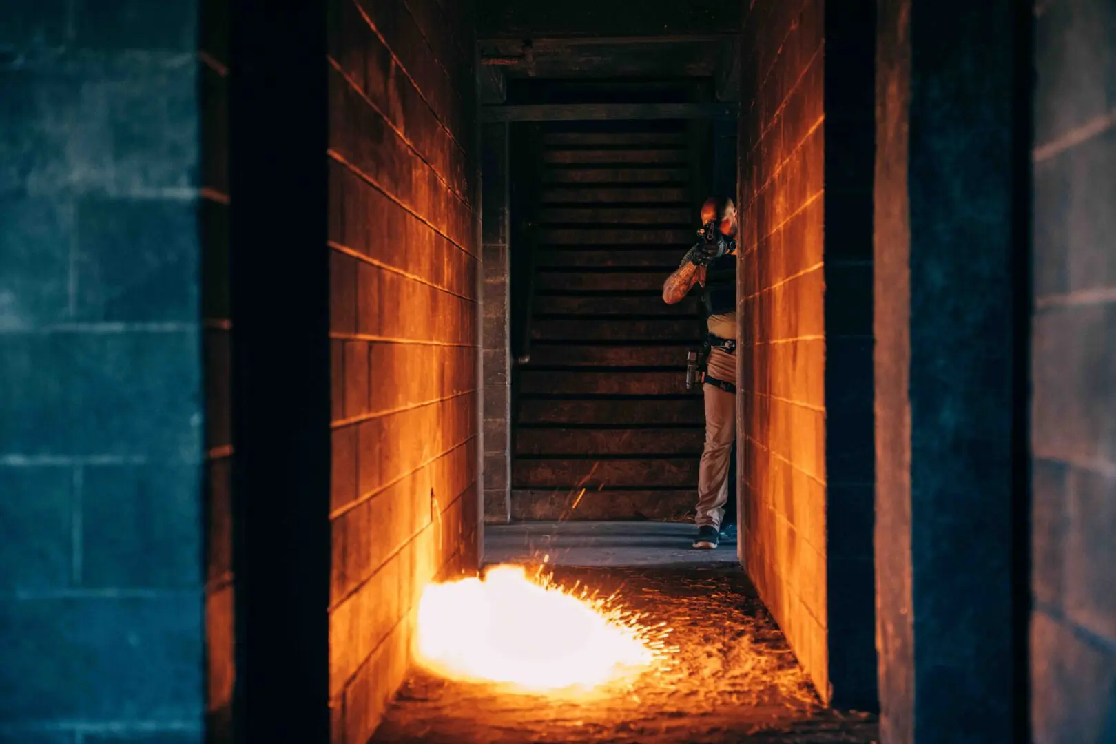 Person using a flamethrower in a dimly lit corridor.