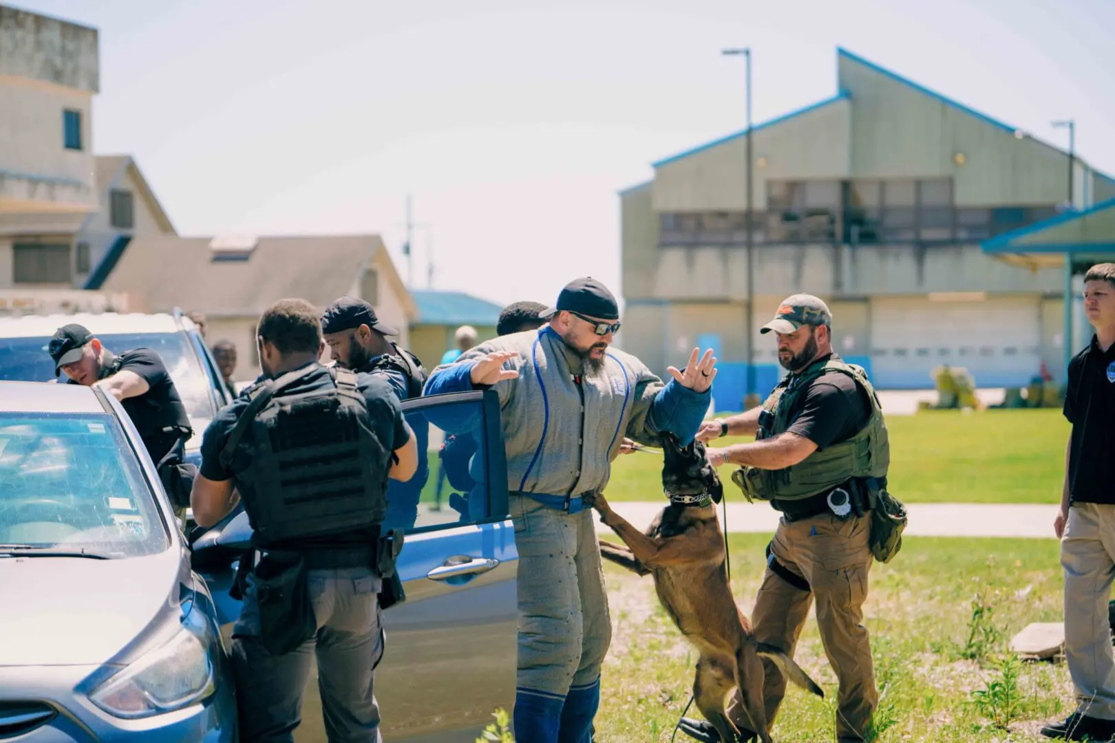 Police officers detain a man during an outdoor operation.